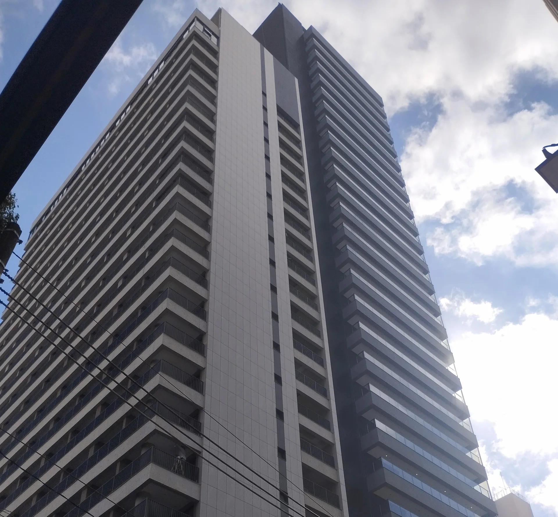 Edifício residencial visto de baixo, com fachada e varandas